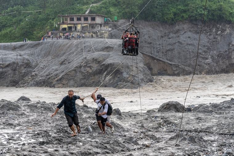 Trading food for medicine and crossing the river by zip line are part of life in Nepal flood zone