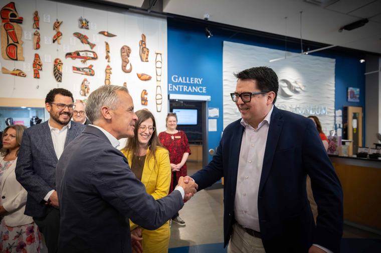 Prime Minister Mark Carney shakes hands with Parliamentary Secretary Wade Grant during a National Indigenous Peoples Day visit to the Nanaimo Museum as Secretary of State Stephanie McLean and MP Will Greaves look on.
